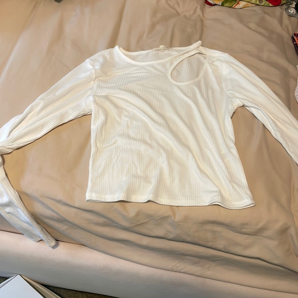 White tee shirt with long sleeves and slit in left hand shoulder. No damage